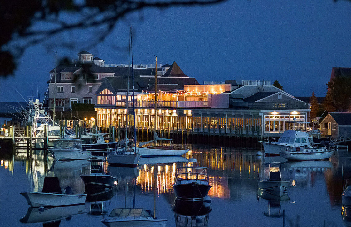 A harbor and exterior of a building at night.
