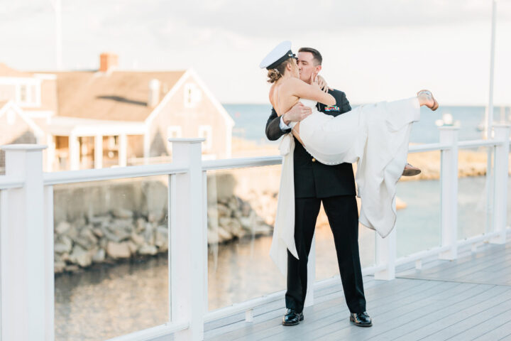 A bride and groom sharing a kiss on a rooftop deck.
