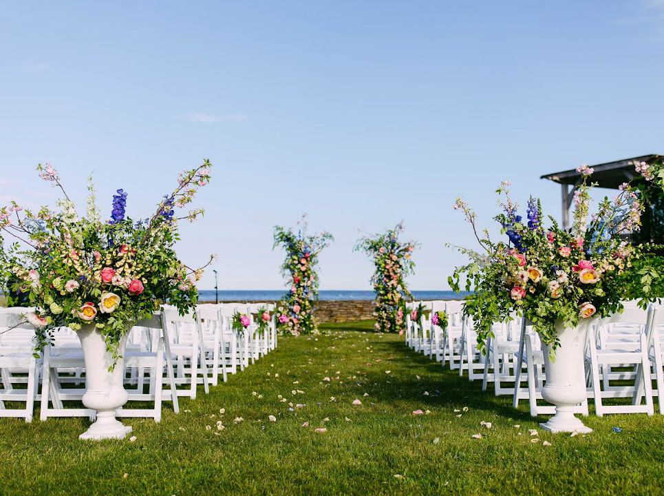 A lawn set up for a wedding ceremony with hydrangeas.