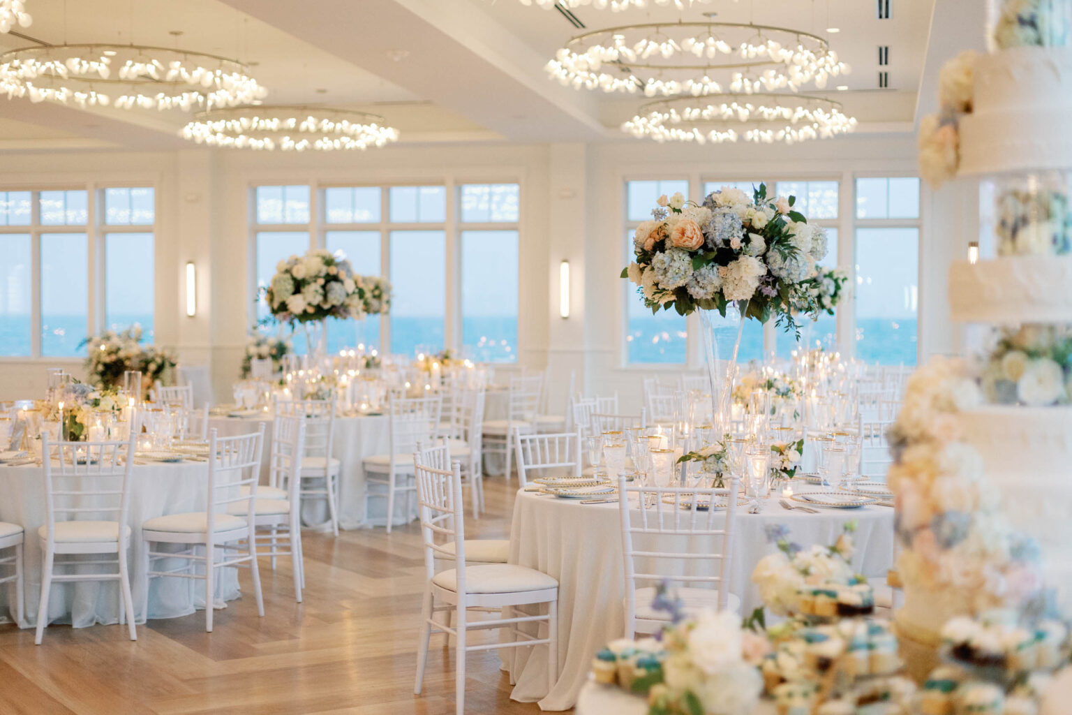 Floral arrangements on tables in an oceanfront wedding venue